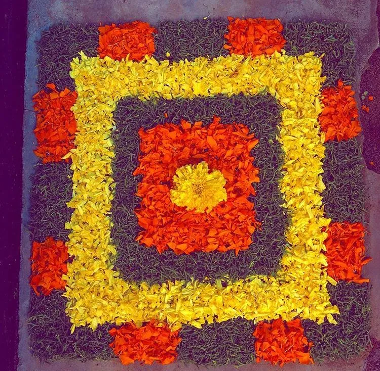 Simple square pookolam design with Marigold petals image