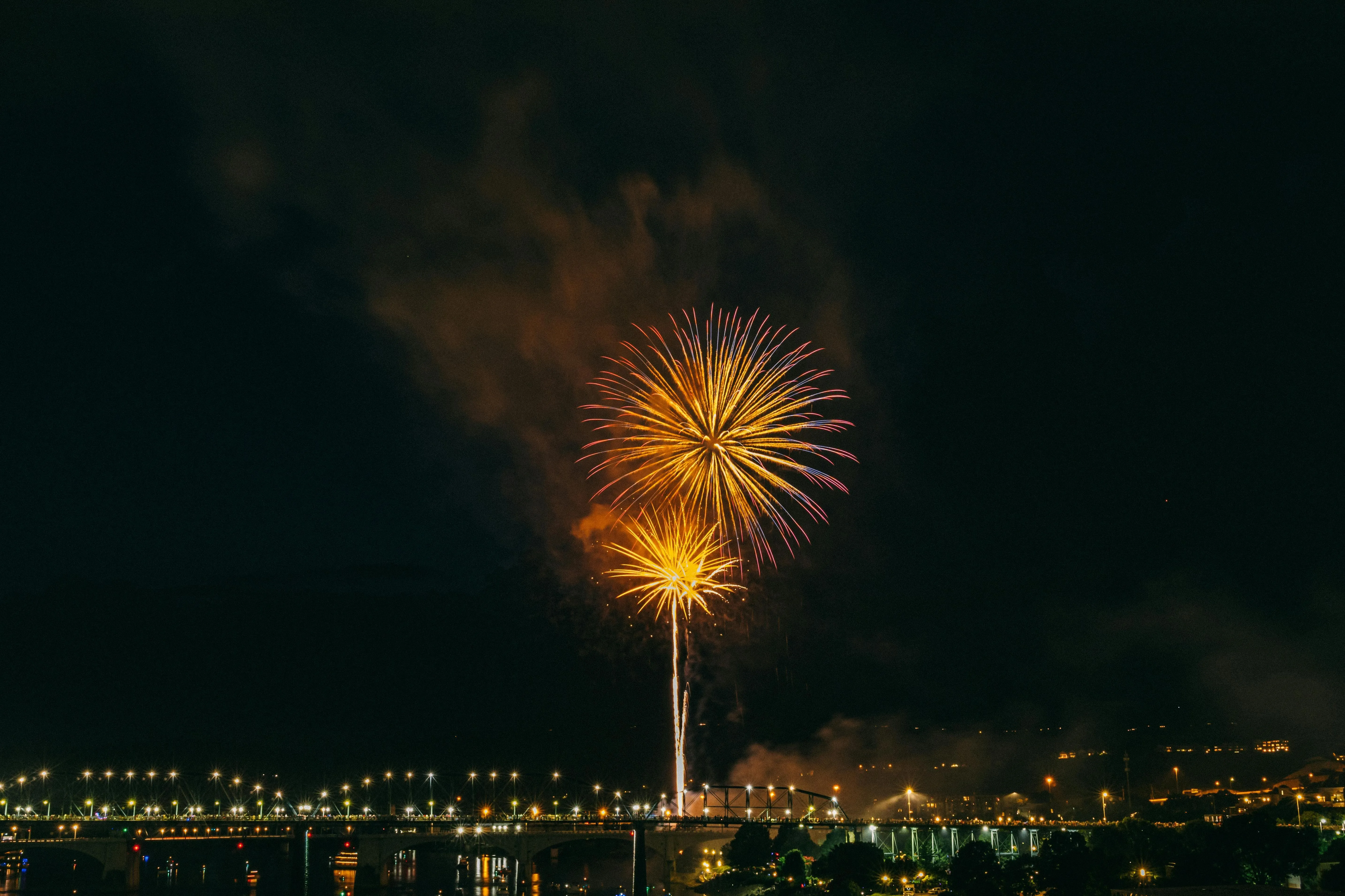 Single firework bursting in the night sky over a city skyline