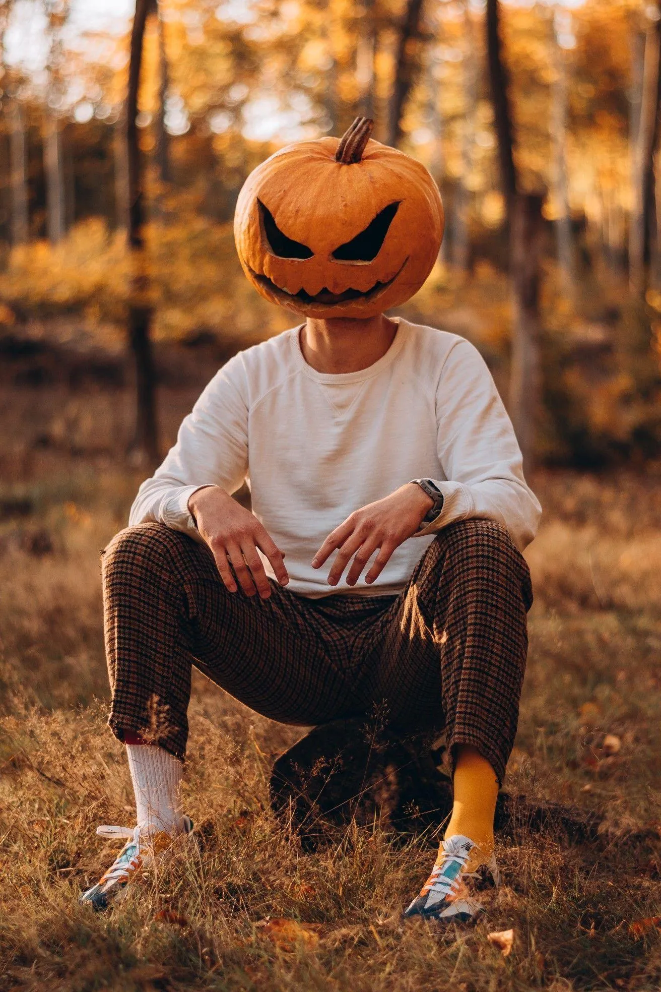 Sitting Alone Pumpkin Head Costume in Autumn Forest