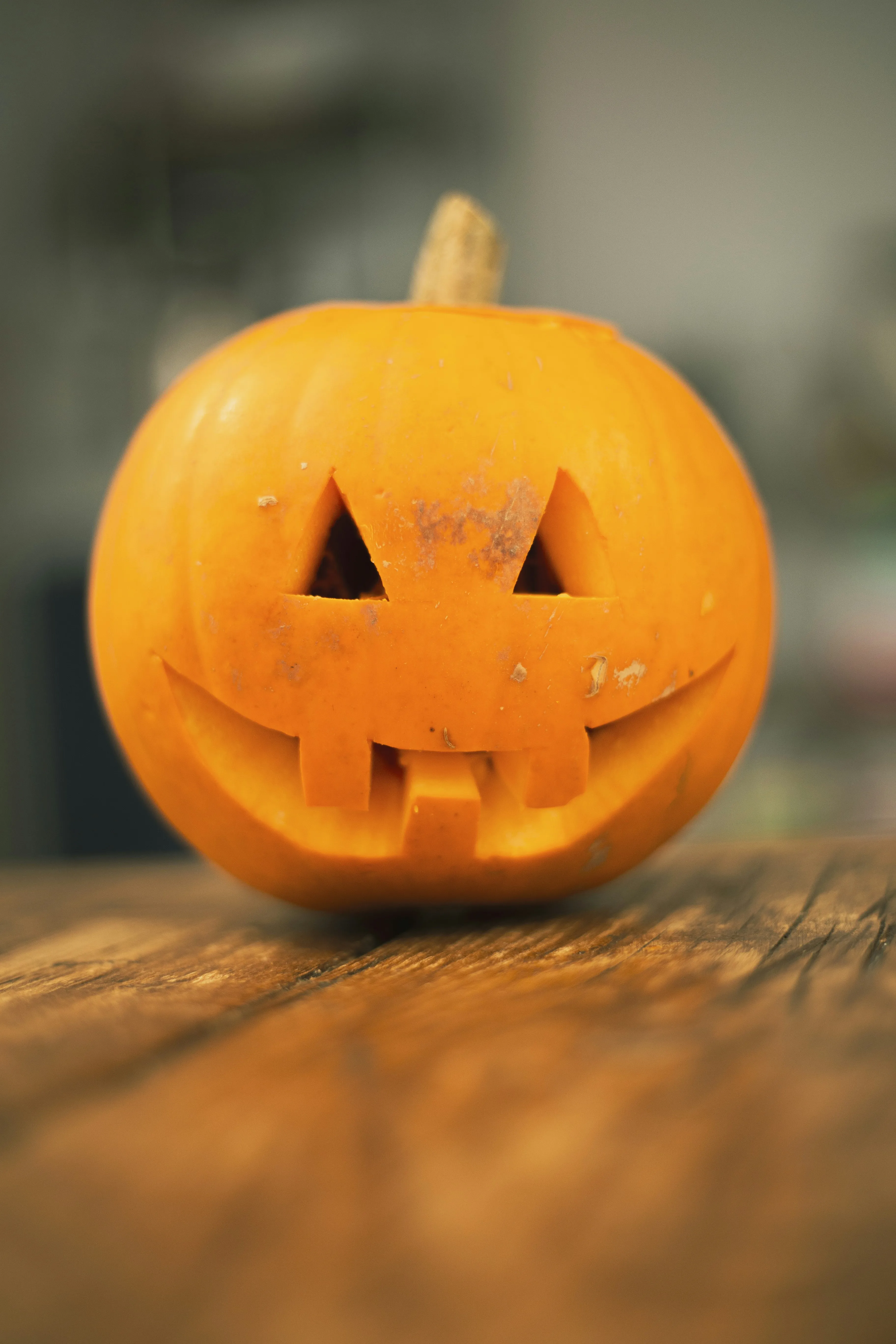 Smiling Carved Pumpkin on Wooden Tabletop 4K Wallpaper