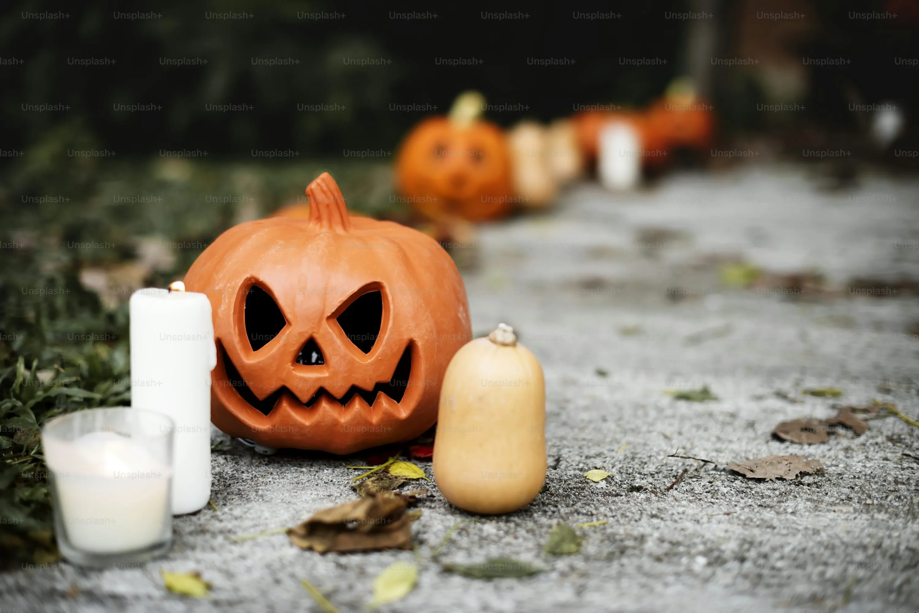 Smiling Pumpkin with Candles on Pavement For Halloween
