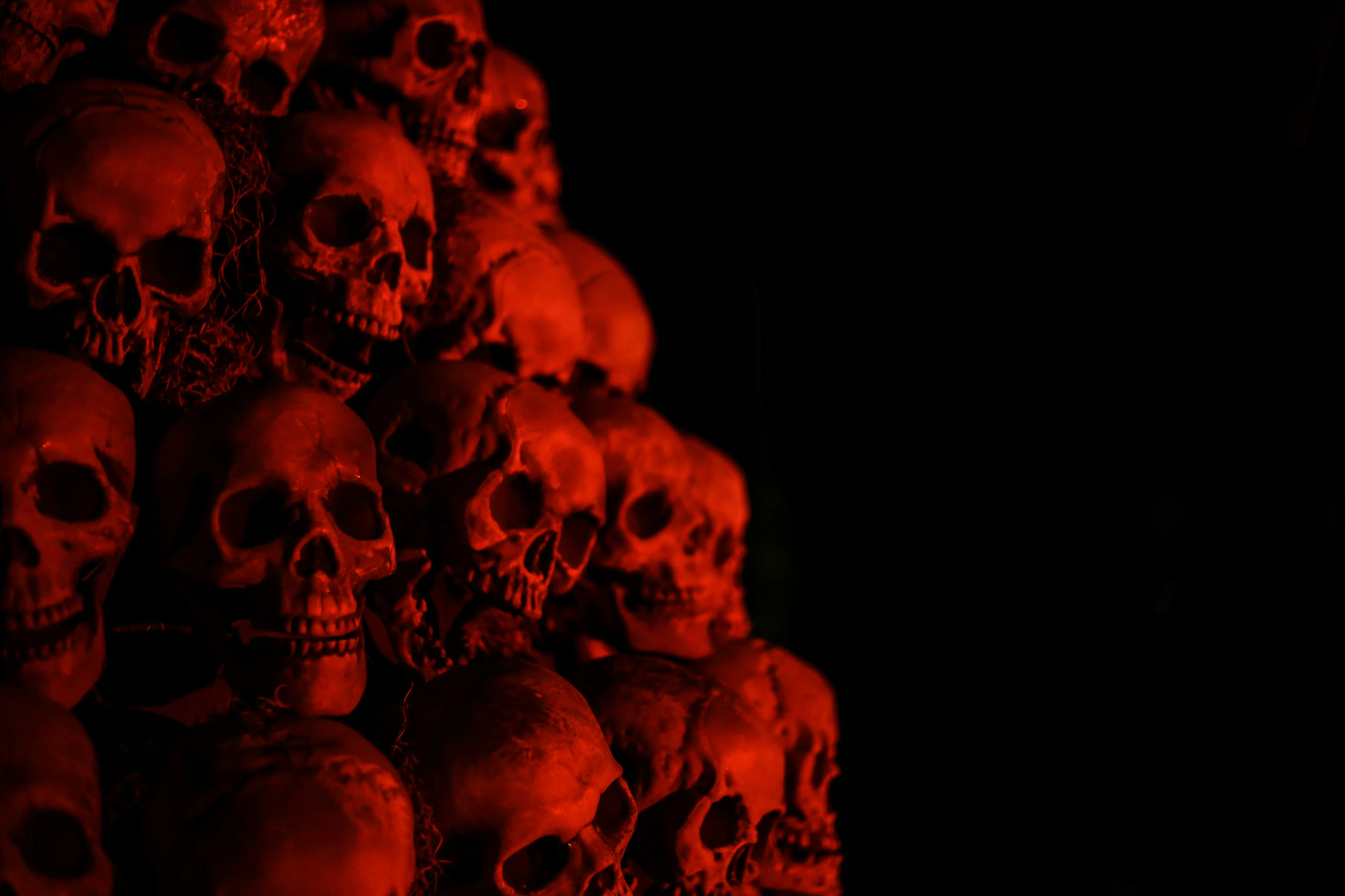 Spooky Pile Of Red Skulls in Dark Setting HD Wallpaper