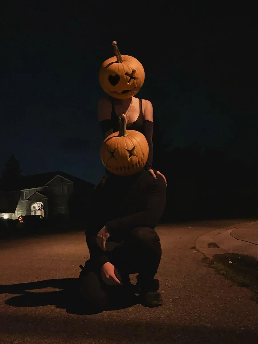 Stacked pumpkins with glowing faces in the dark night