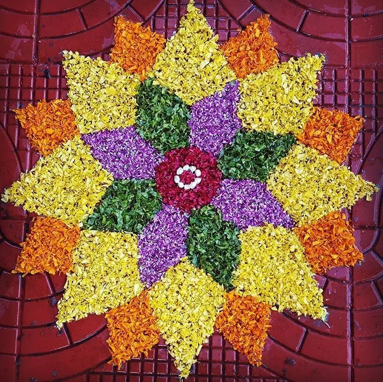 Star shaped Onam pookalam with yellow and purple petals
