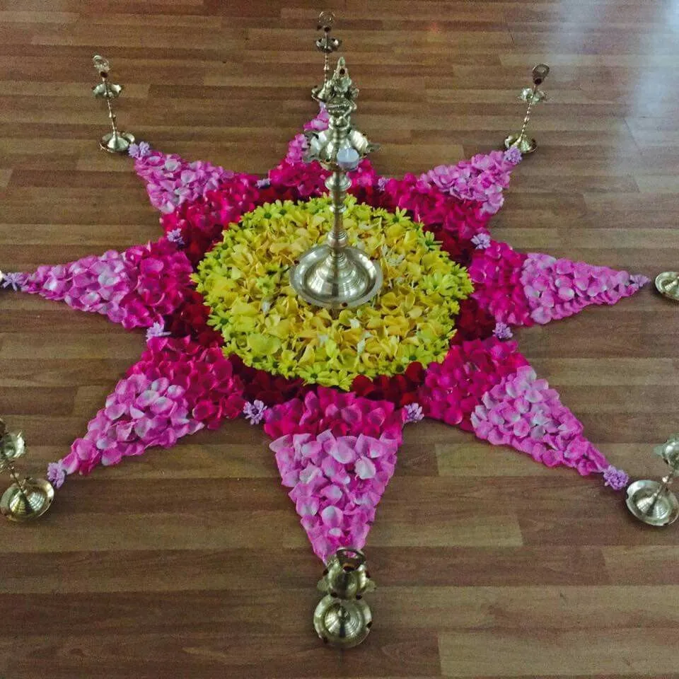 StarmShaped Onam Pookalam with lamps and flower Petals image