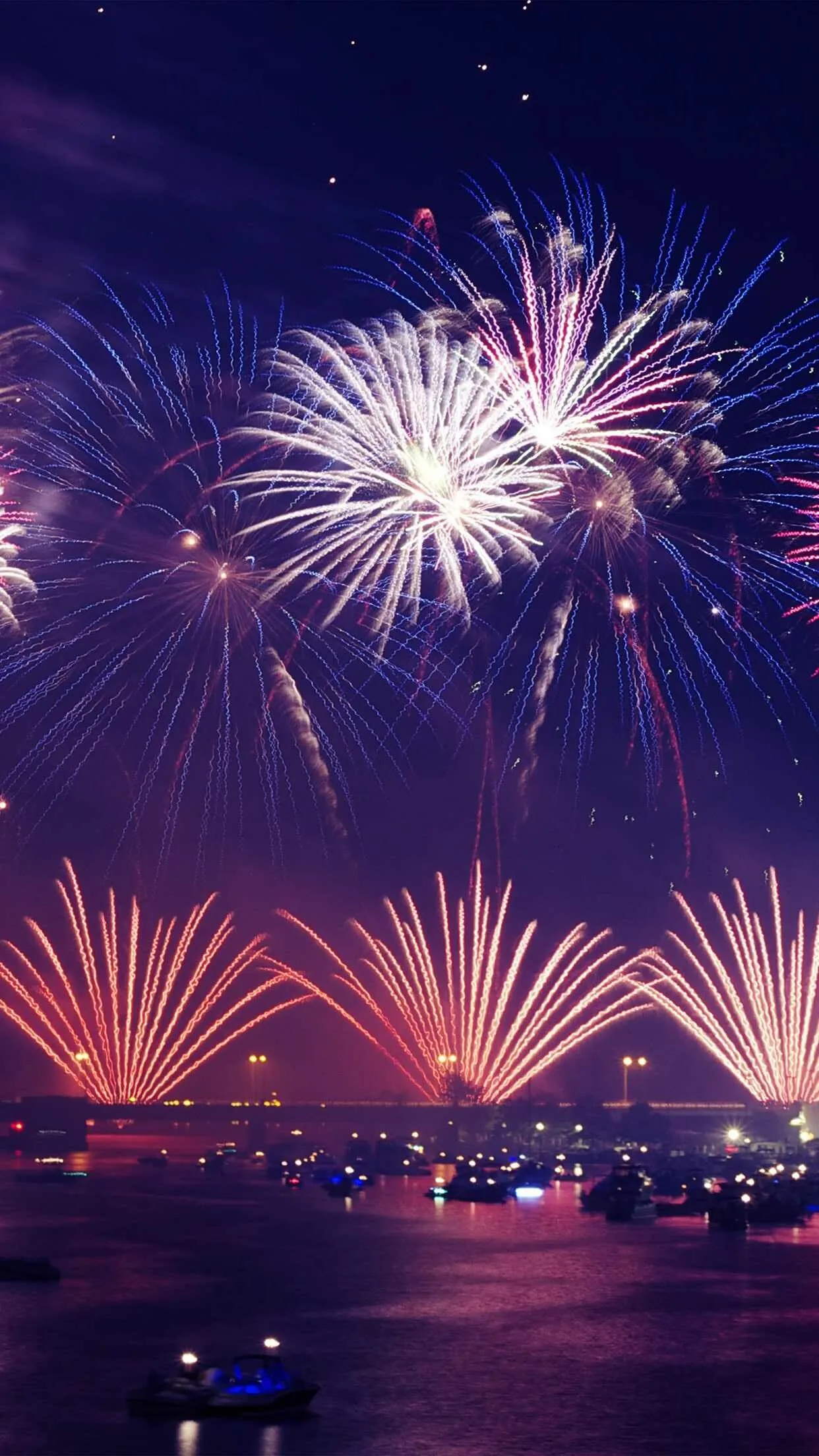 Stunning night sky fireworks display over water reflections