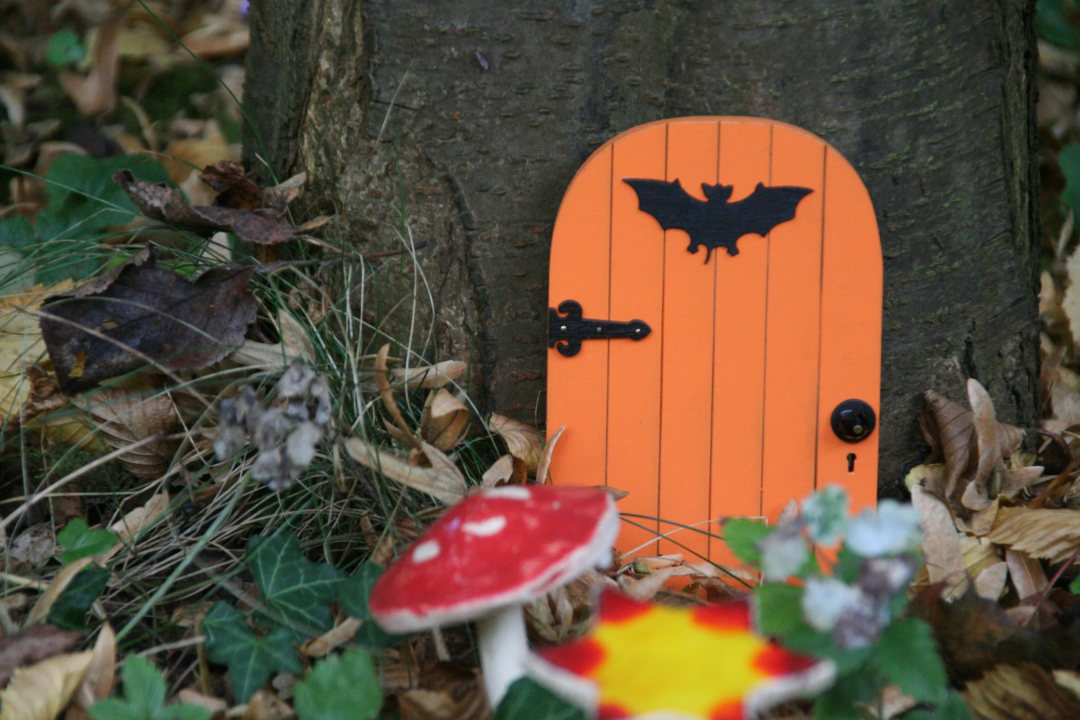 Tiny Halloween Door with Bat and Mushrooms on Tree Wallpaper