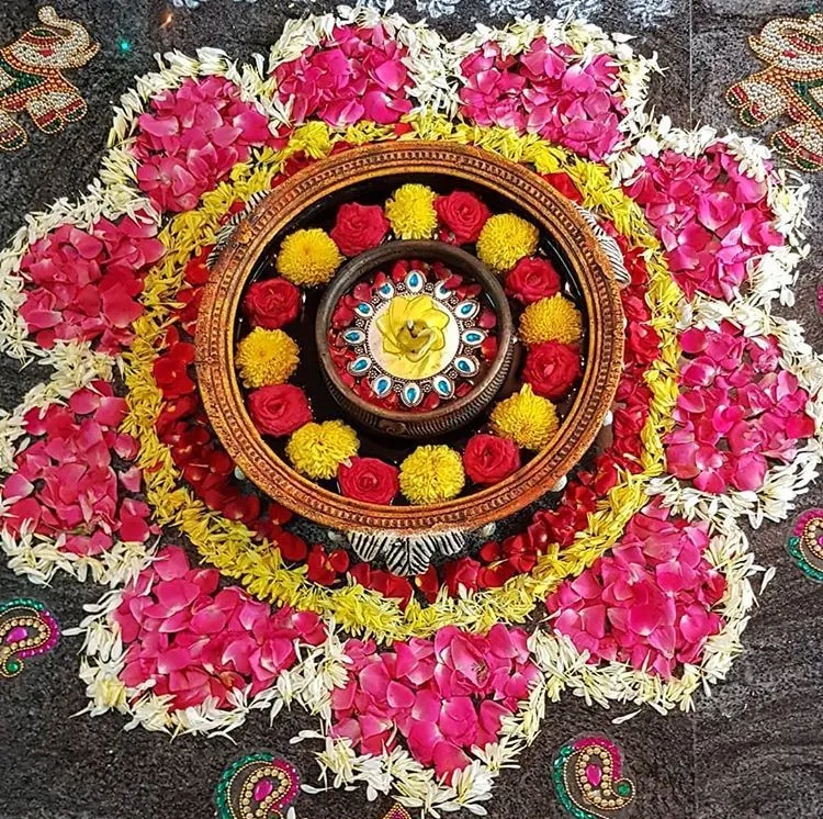 Traditional bowl decoration with white and red petals kolam