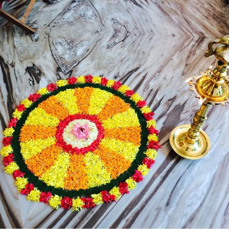 Traditional colourful Onam rangoli with a brass lamp image