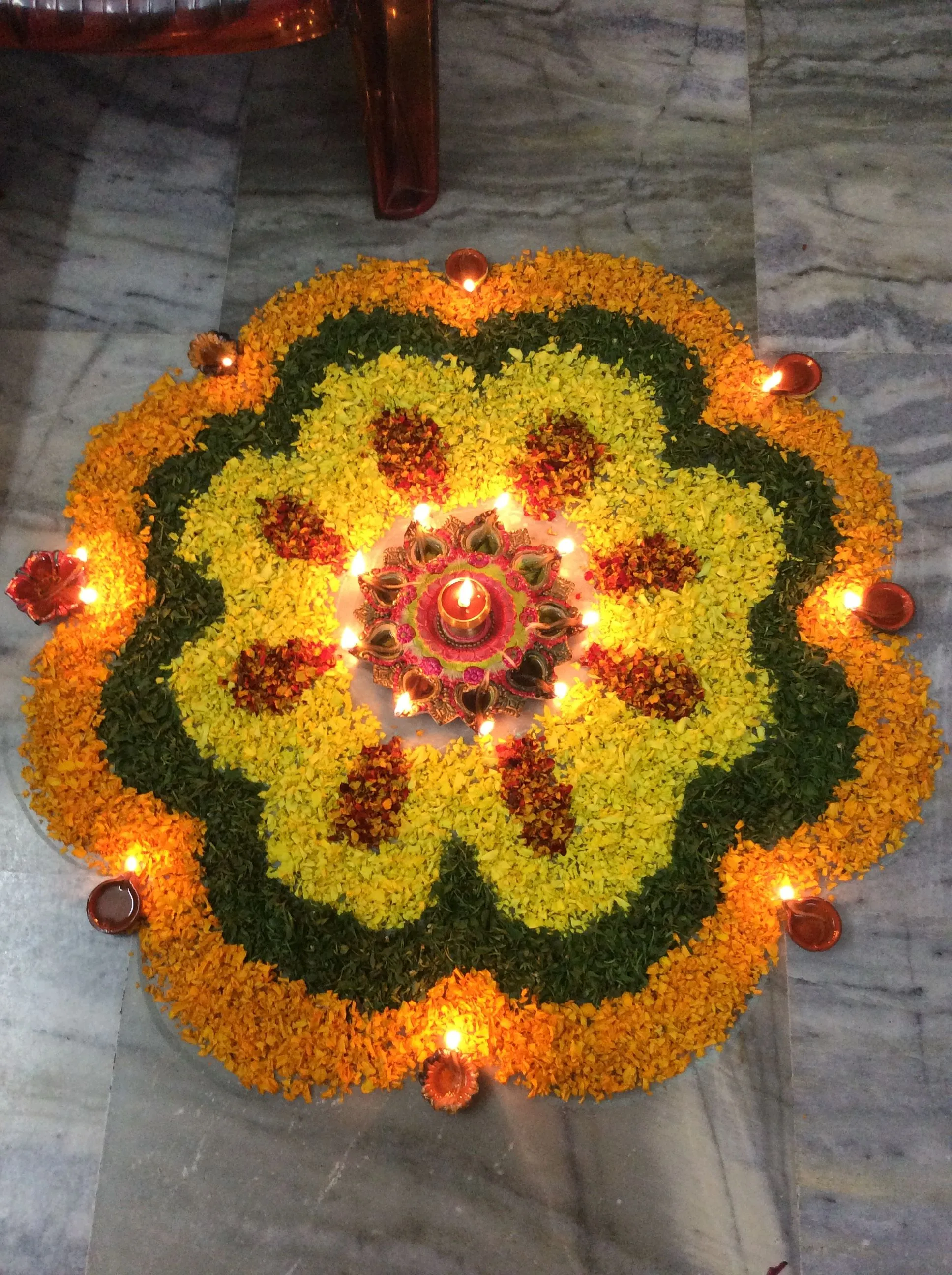 Traditional floral rangoli design with oil lamps for festival