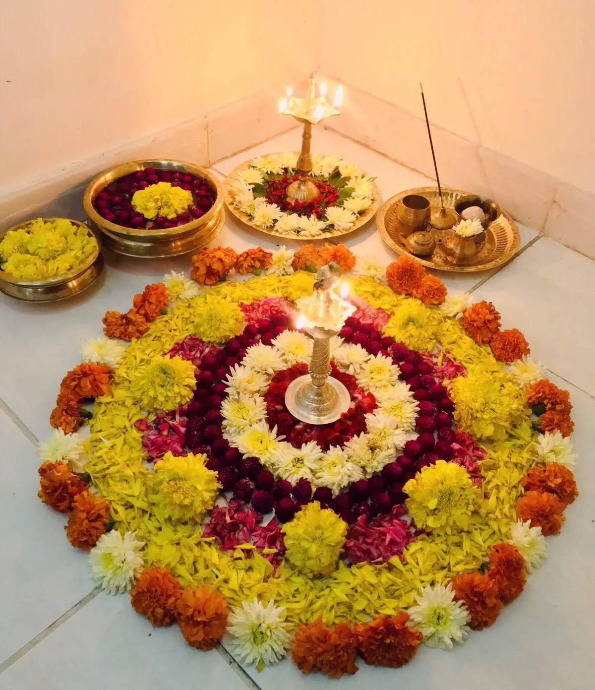 Traditional Onam Athpookolam with lamp and vessels Wallpaper