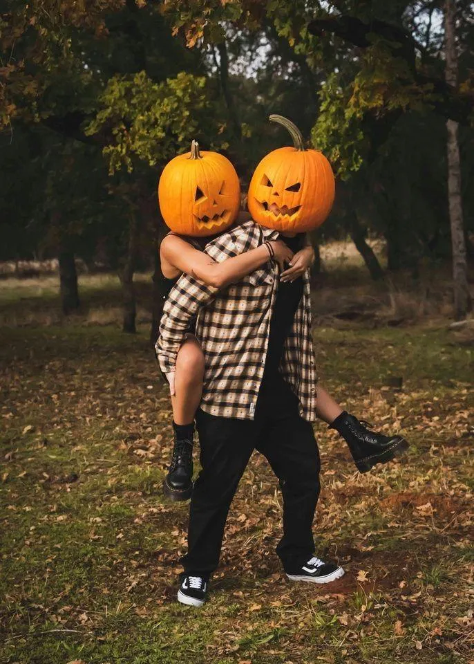 Two Friends Wearing Matching Pumpkin Head Costumes