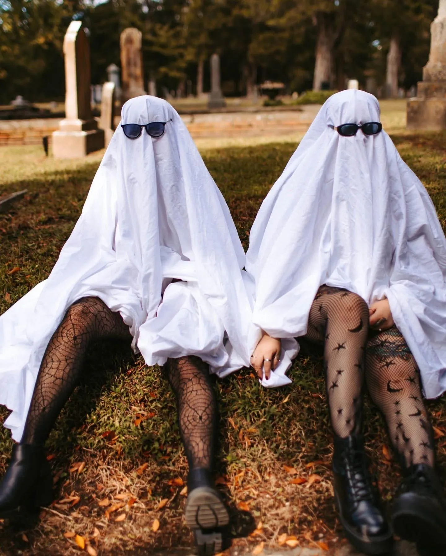 Two Ghost Costumes Sitting Together on Grass image