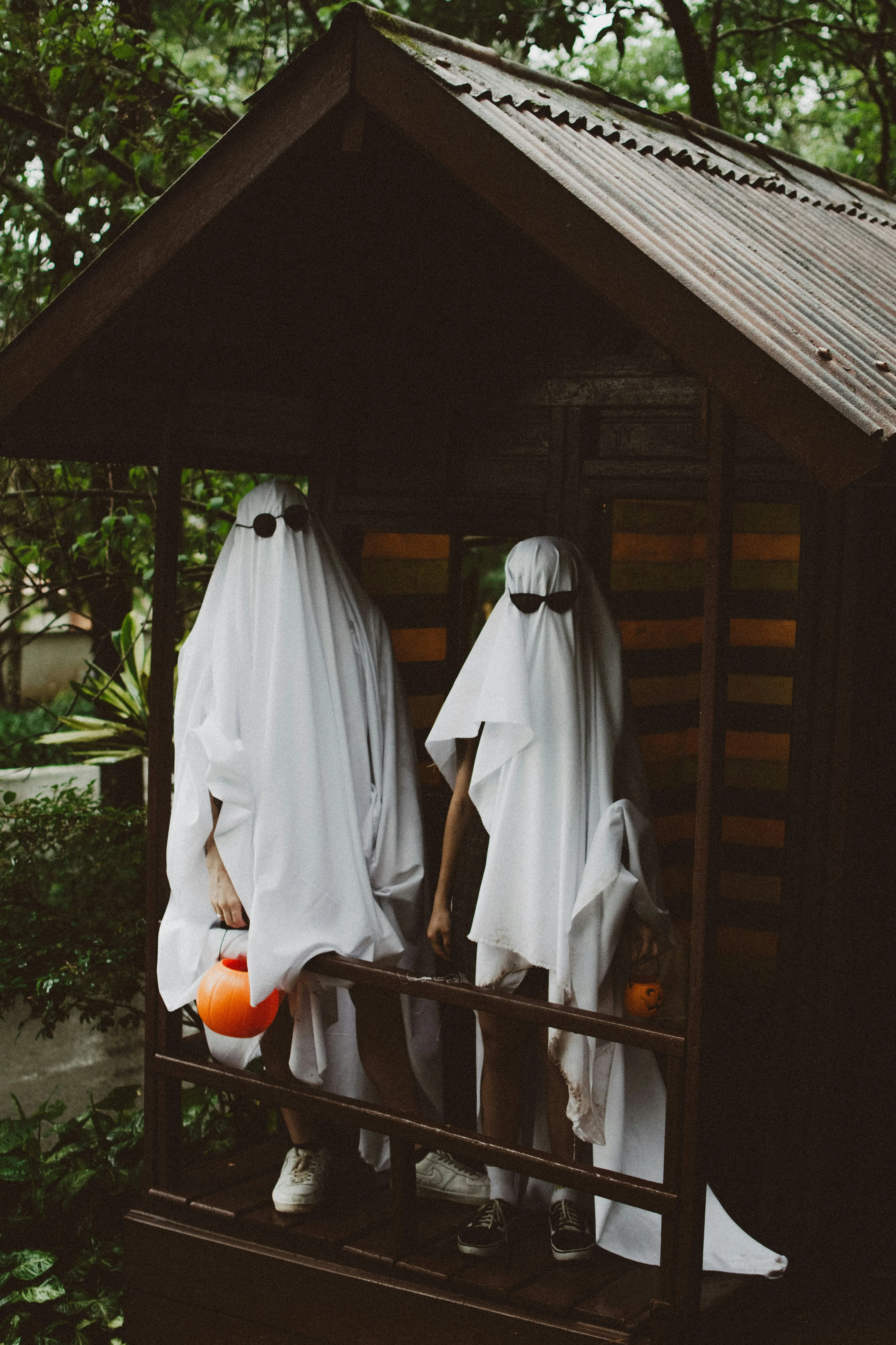 Two Ghosts Holding Pumpkin Bucket at Halloween Festival