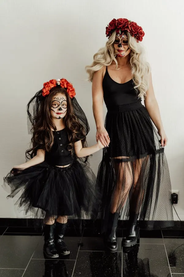 Two Girls Dressed in Gothic Dresses with Red Flowers