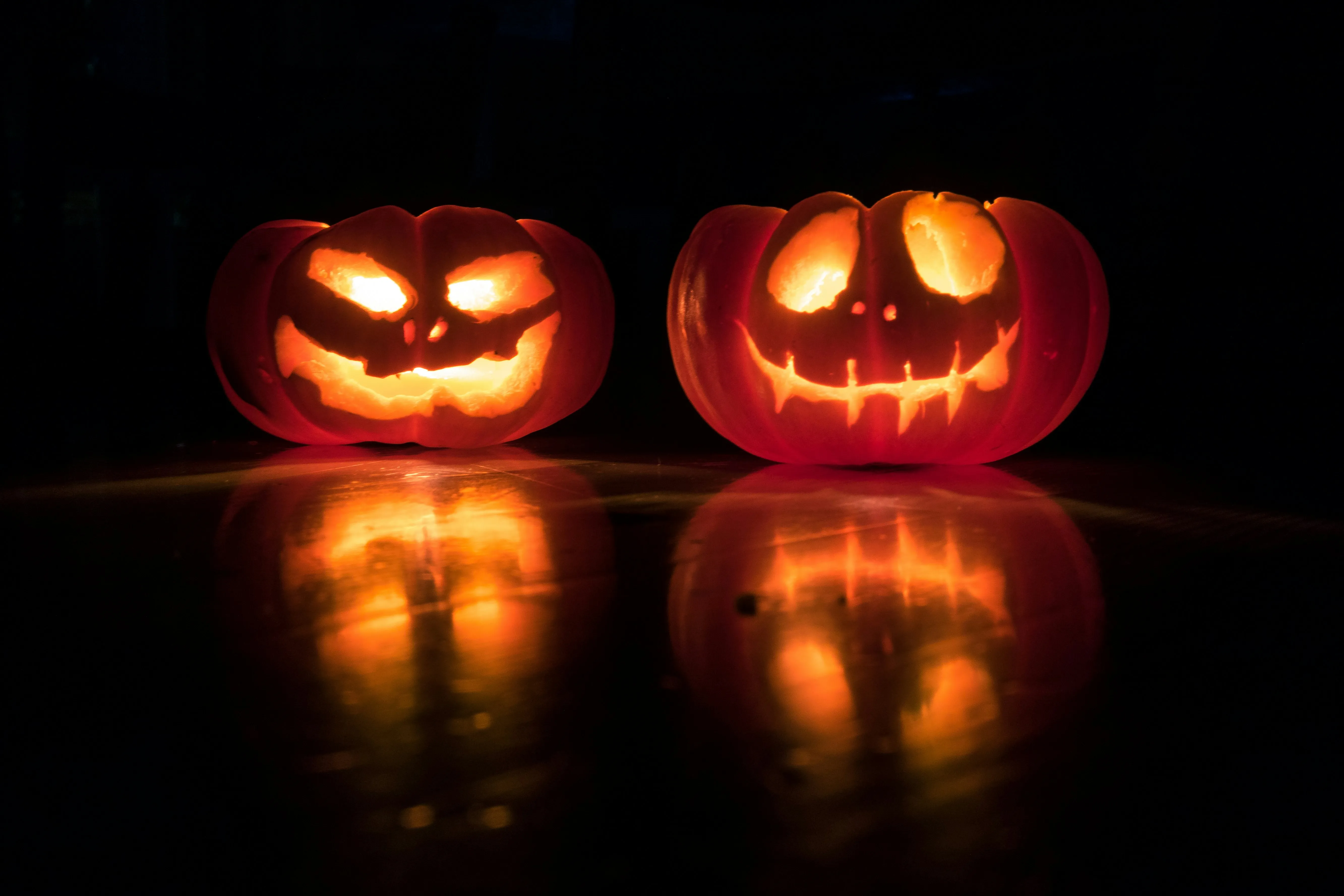 Two Lit Jack O Lanterns Reflected on Shiny Surface Image