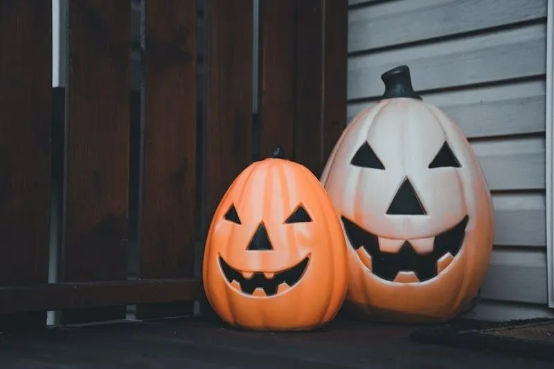 Two Painted Jack O Lanterns on Porch By Wooden Door