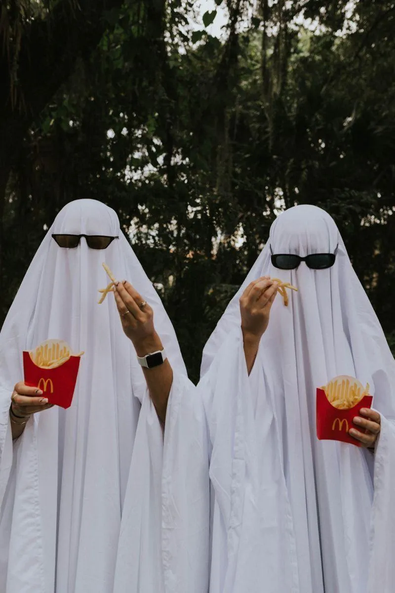 Two People Wearing Ghost Costumes Holding Candy Buckets