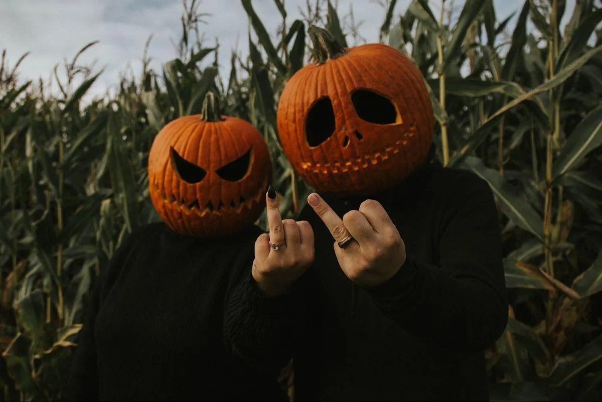 Two People Wearing Pumpkin Head Masks posing Outdoors