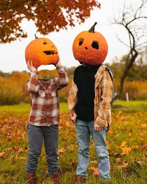 Two People with Pumpkin Heads in Fall Setting Wallpaper
