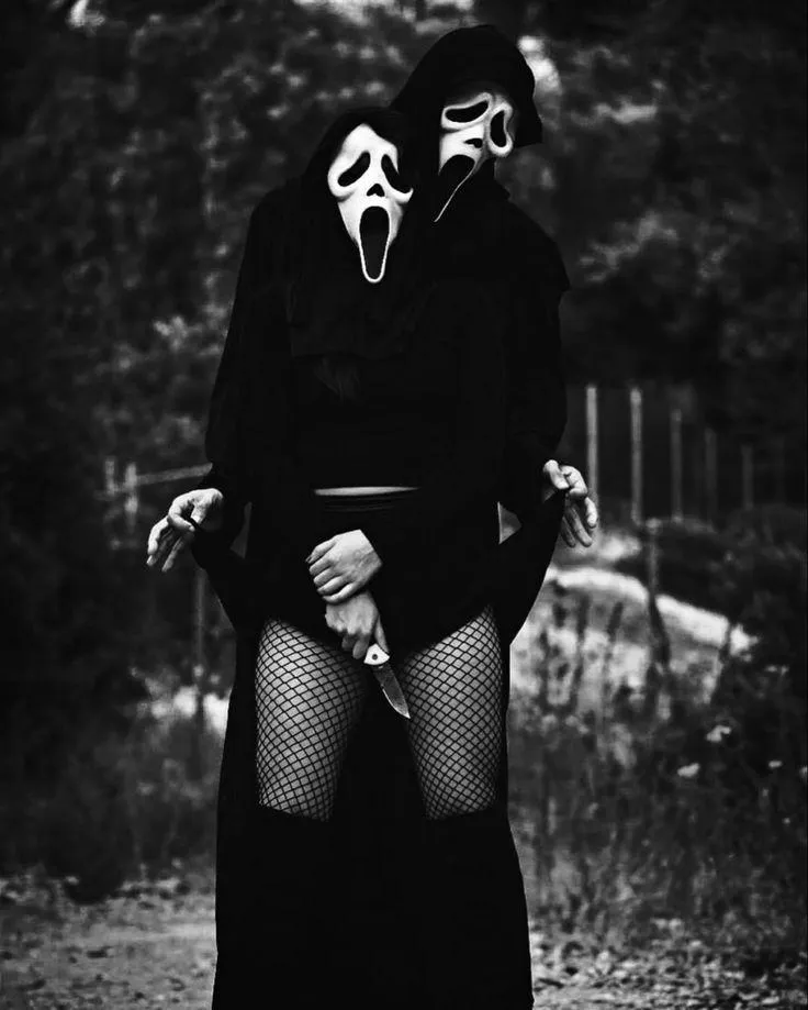 Two Person in ghost mask and fishnet tights standing outside