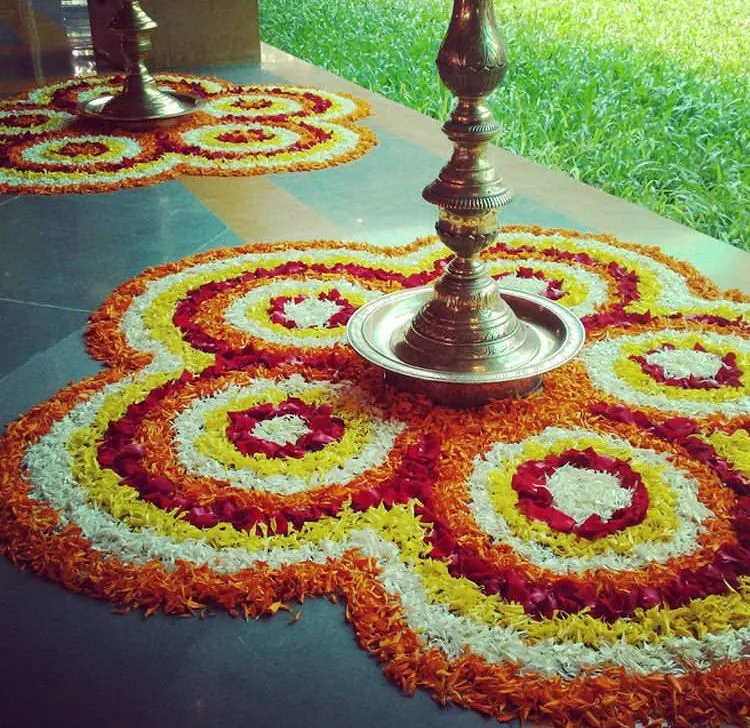 Two rounded floral pookolam with traditional lamp image