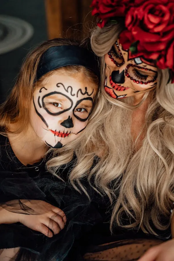 Two Women in Halloween Makeup with Orange and Red Flowers