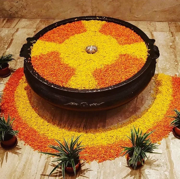 Uruli pookalam with yellow and orange petals free HD image