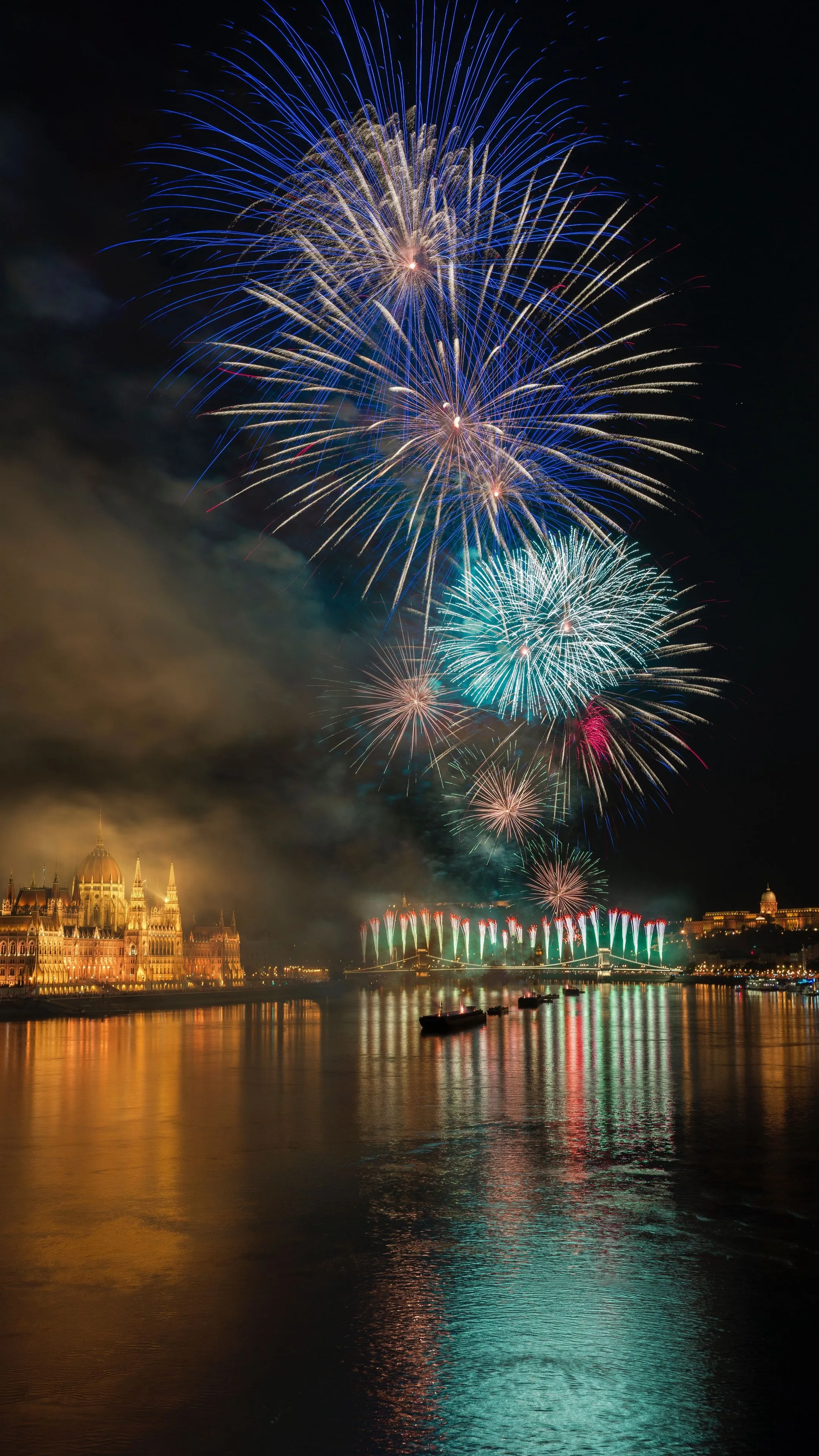 Vibrant fireworks reflecting on calm water at night