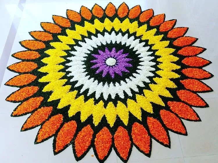 Vibrant floral layered pookolam with orange petal design