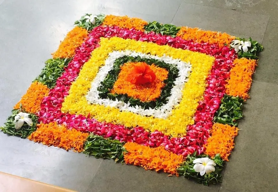 Vibrant layered square Pookolam with hibiscus at the center