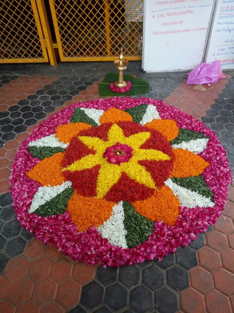 Vibrant Onam Pookalam design with flowers and Lamp image