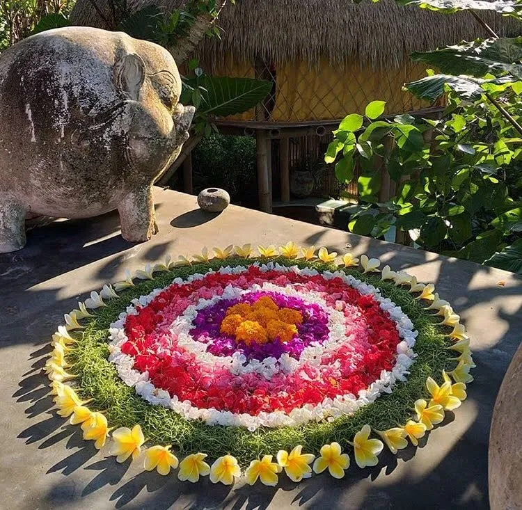 Vibrant Onam pookolam with Tropical flowers and statue