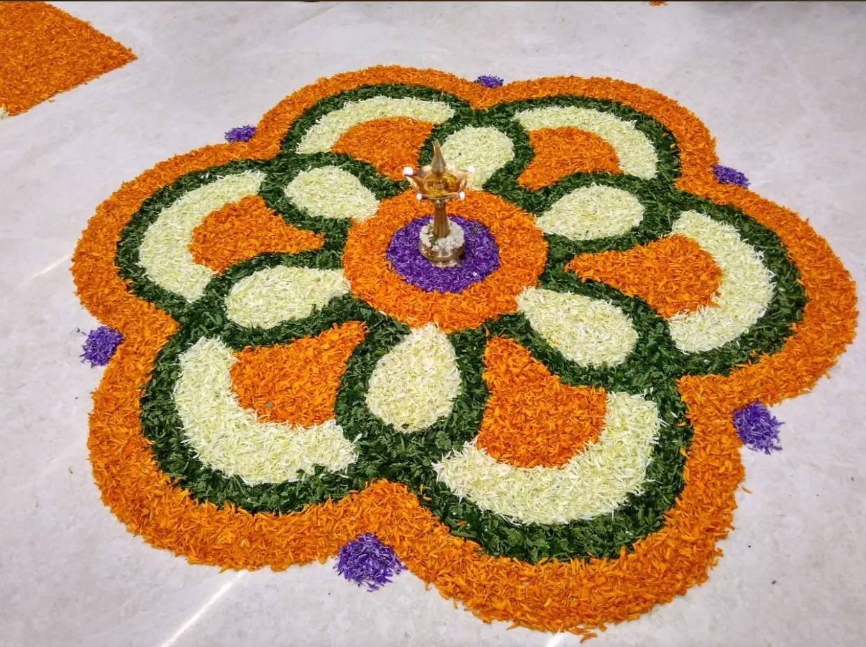Vibrant Pookalam Design with orange green and white Flowers
