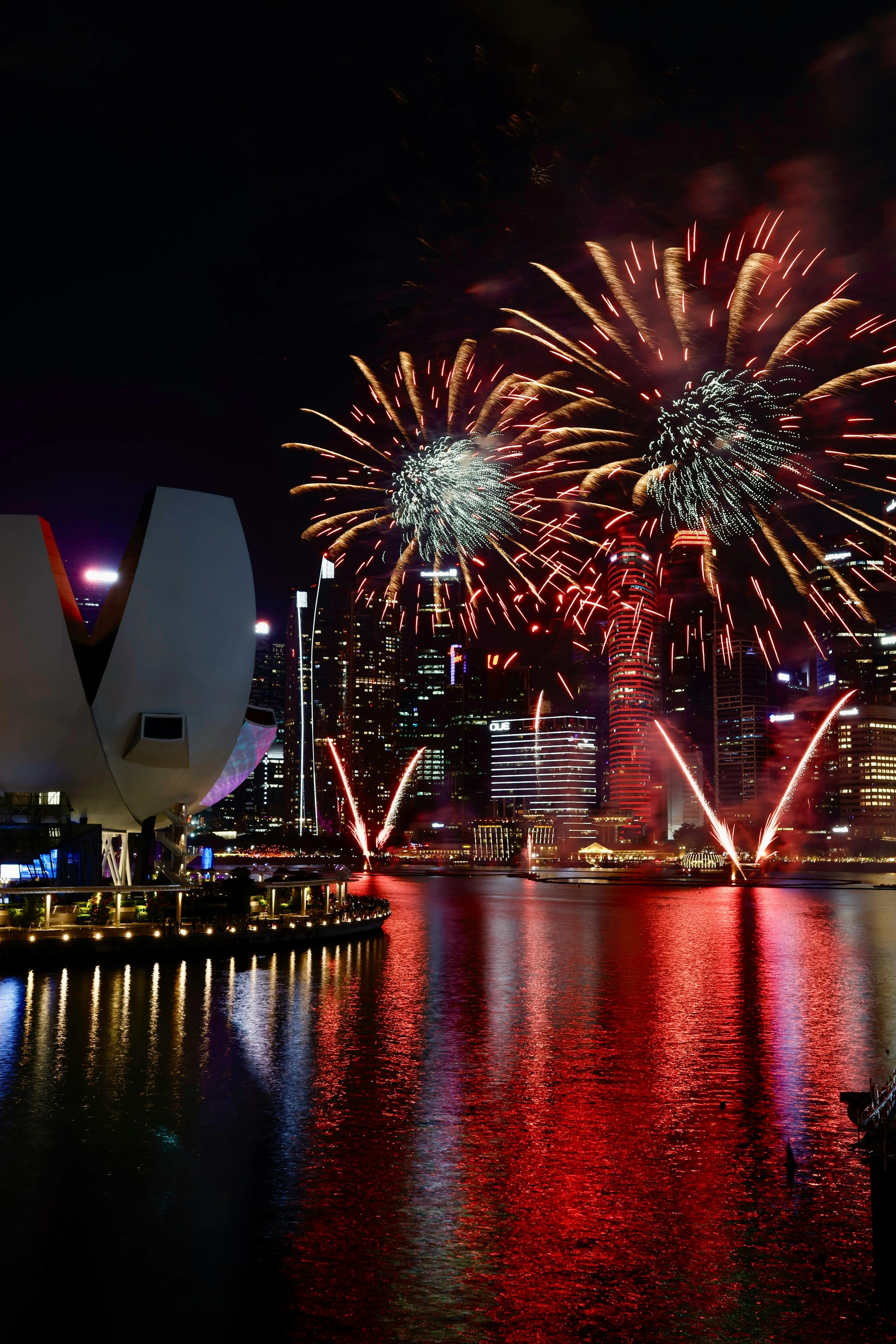 Waterfront City Lit up by Red and White Fireworks image