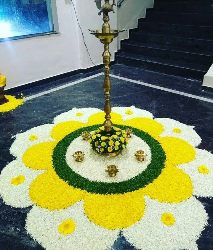 White and yellow floral pattern Athapookolam with lamp image