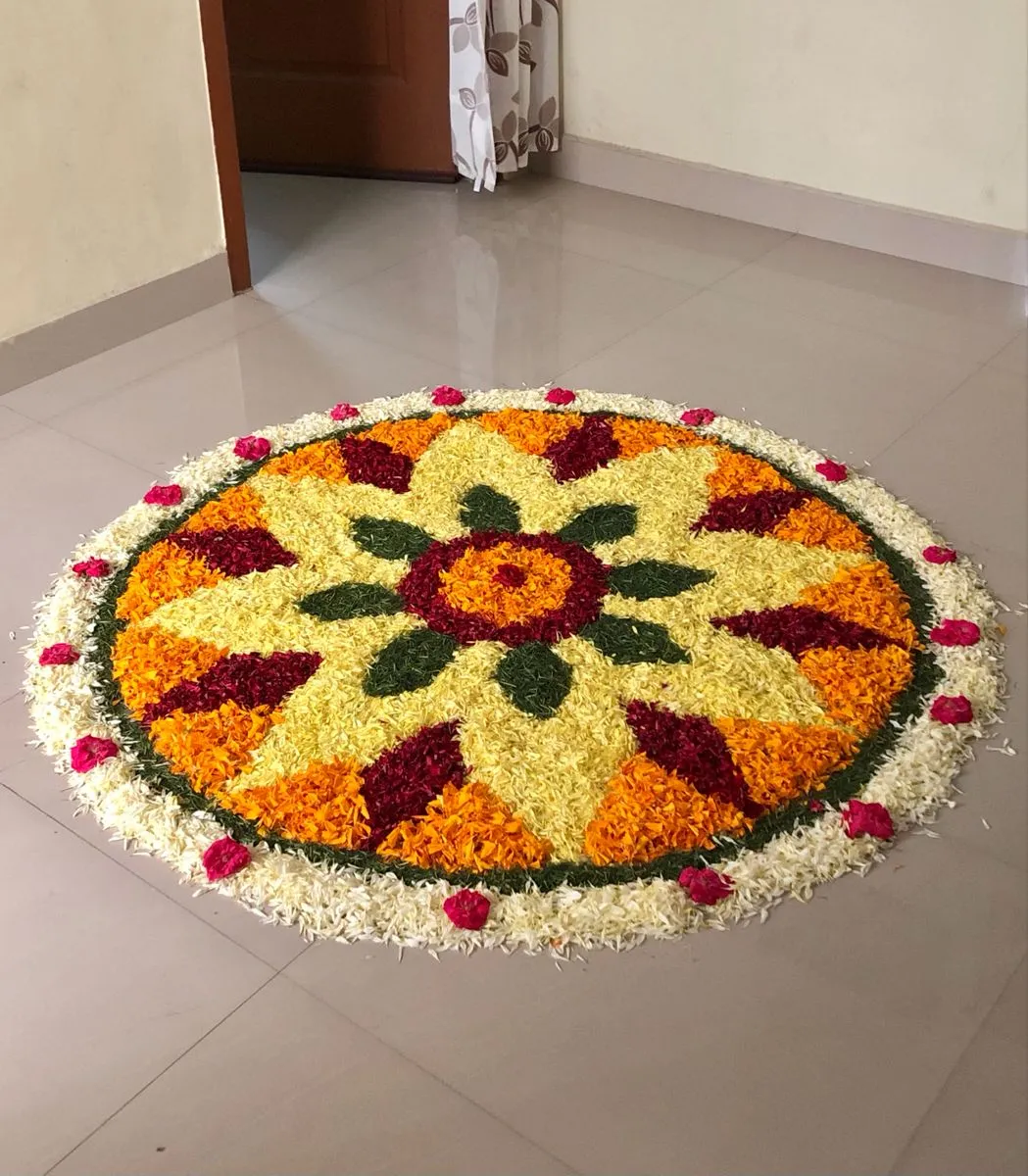 White circular layered flower pookolam with rose details