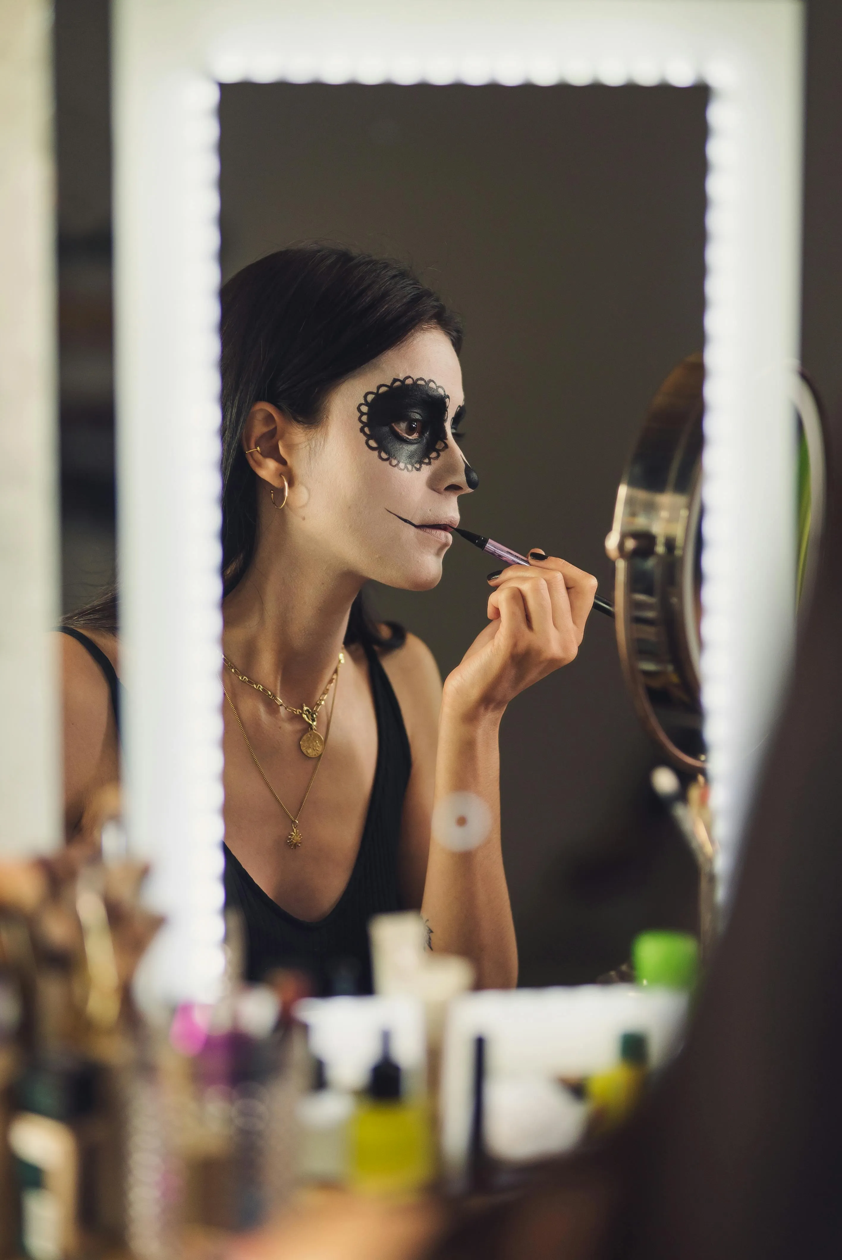 Woman Applying Halloween Makeup in Front of Mirror Wallpaper