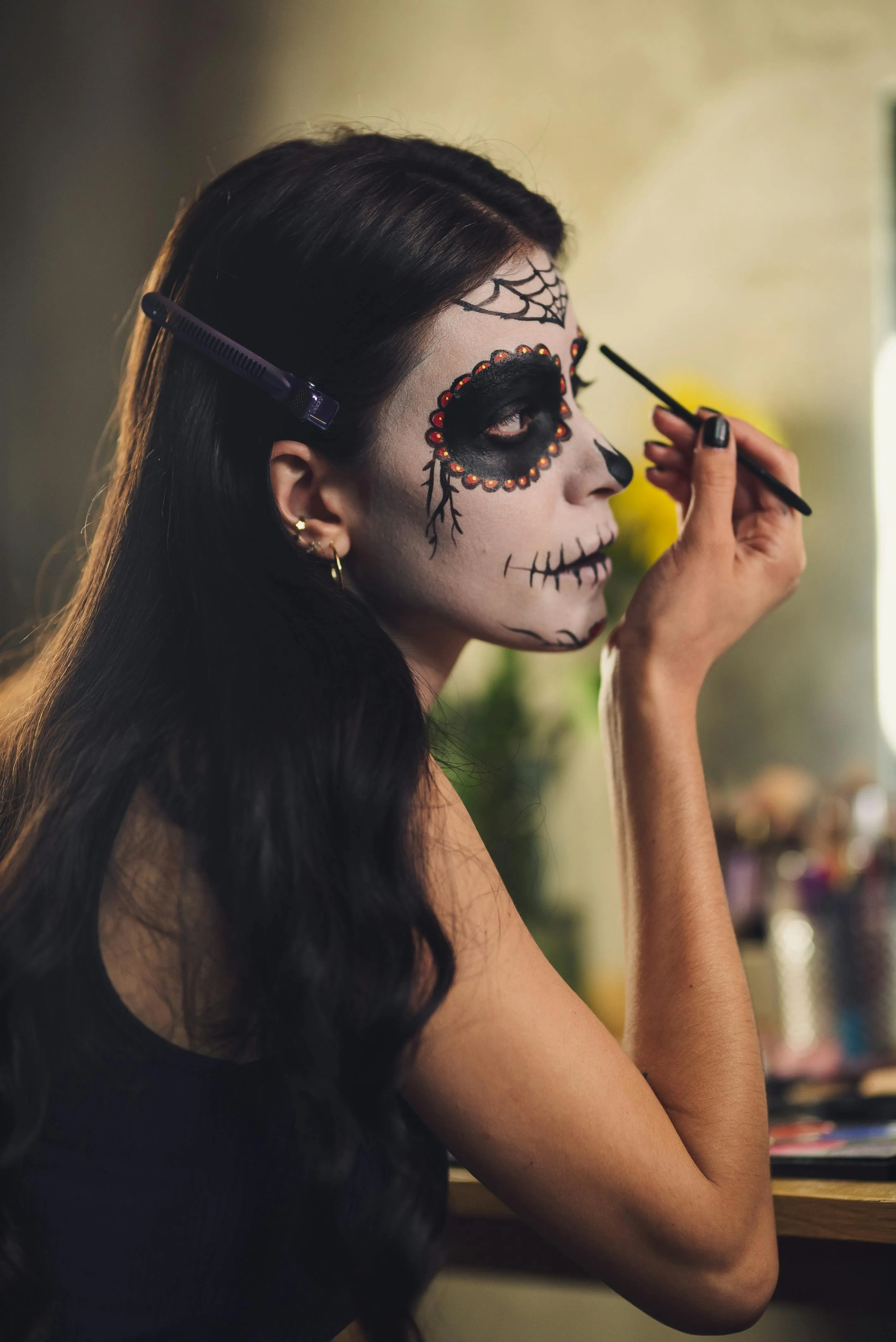 Woman Applying Sugar Skull Makeup for Day of the Dead