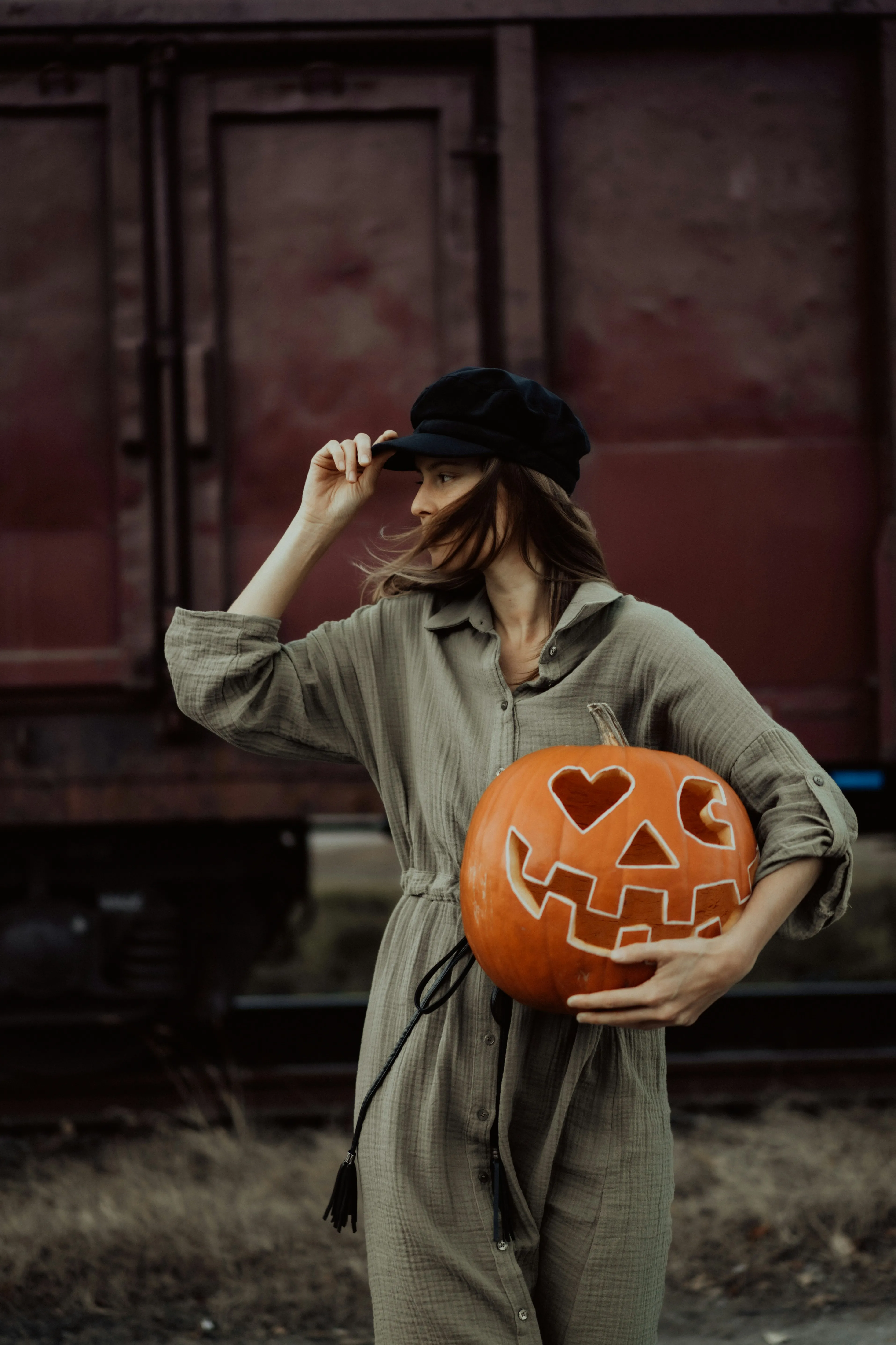 Woman Holding Pumpkin Near Train For Halloween Wallpaper