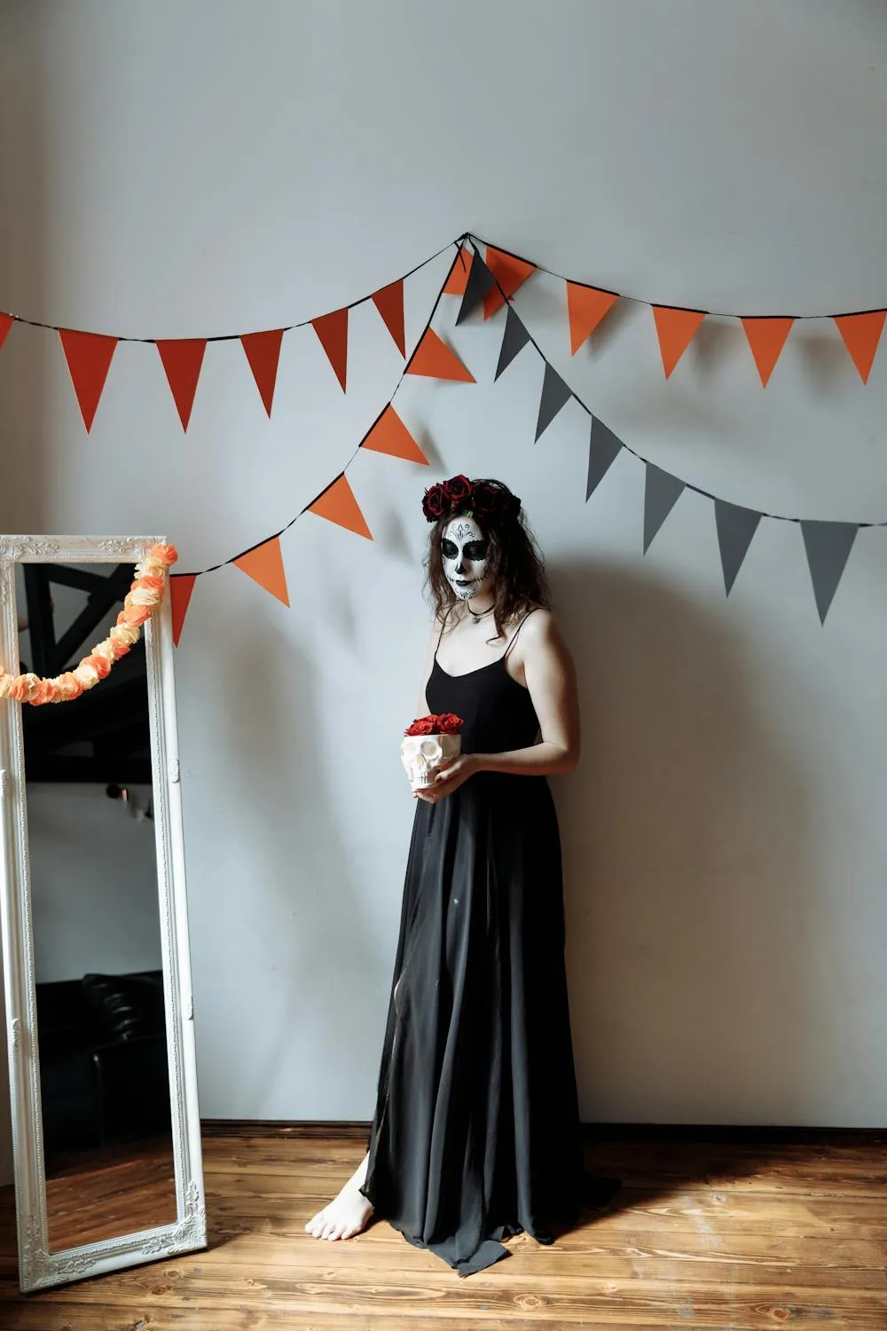 Woman in Black Dress Holding Pumpkin Near Halloween Banners