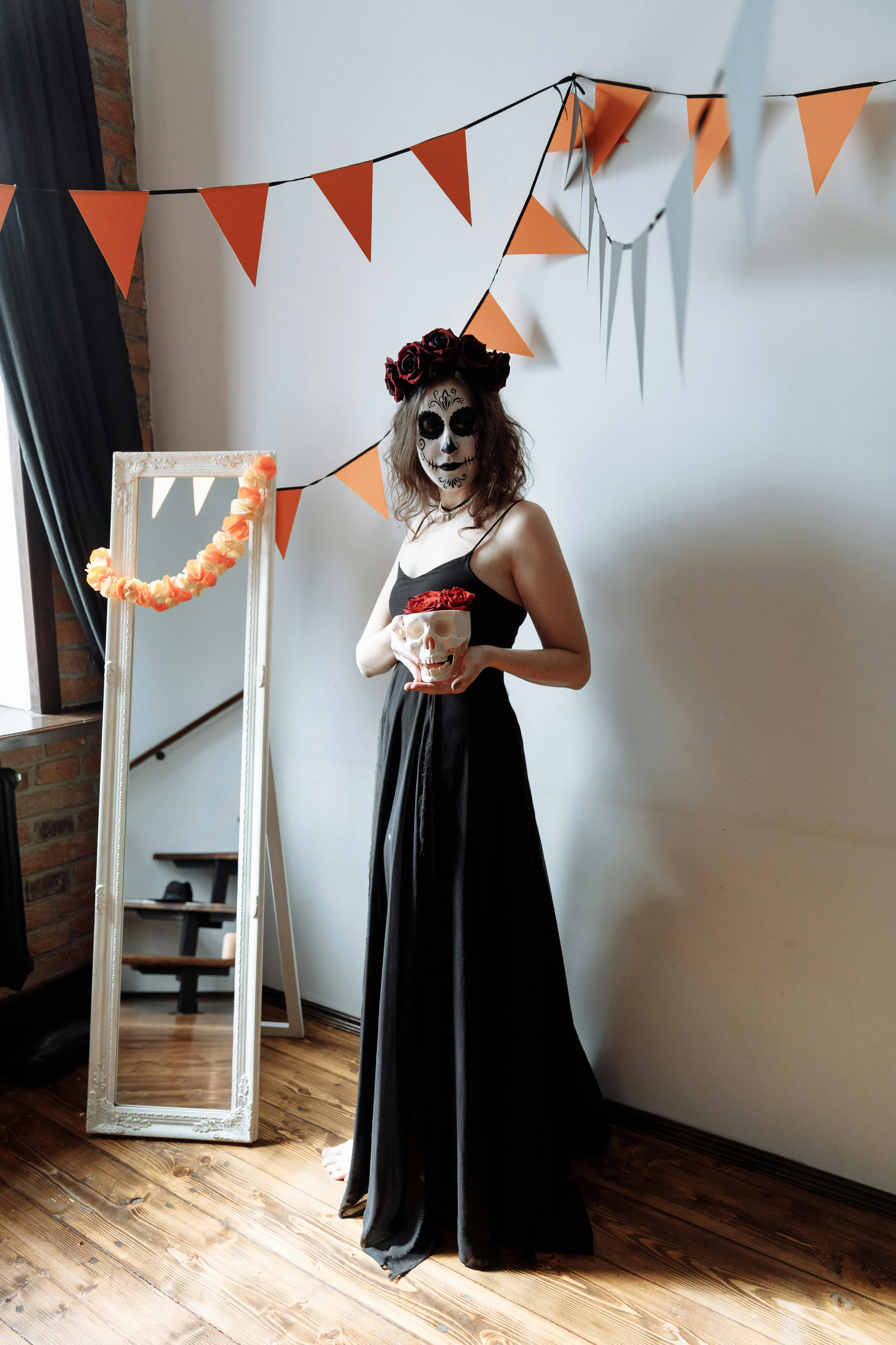 Woman in Black Dress Holding skull at Halloween Party