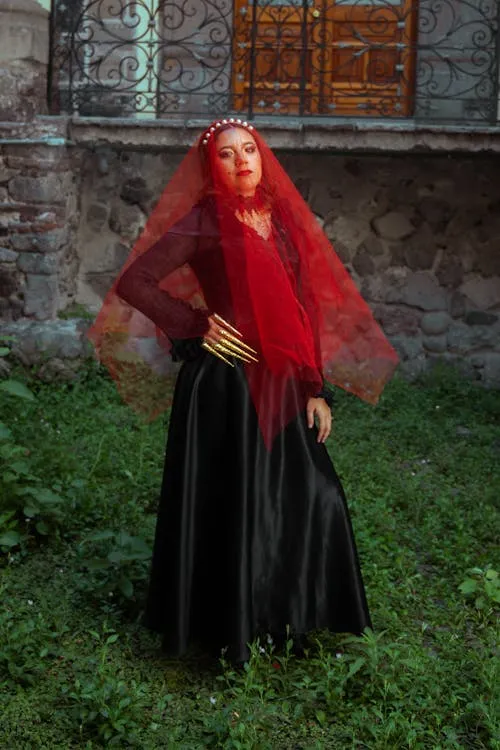 Woman in black dress with red veil at Halloween fest