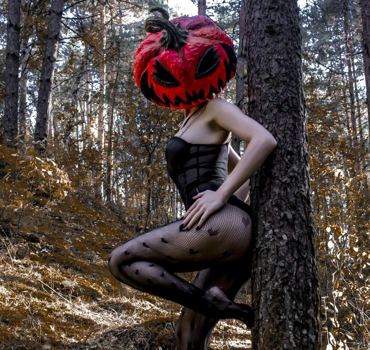 Woman in Black Outfit with Red Pumpkin Head in Woods