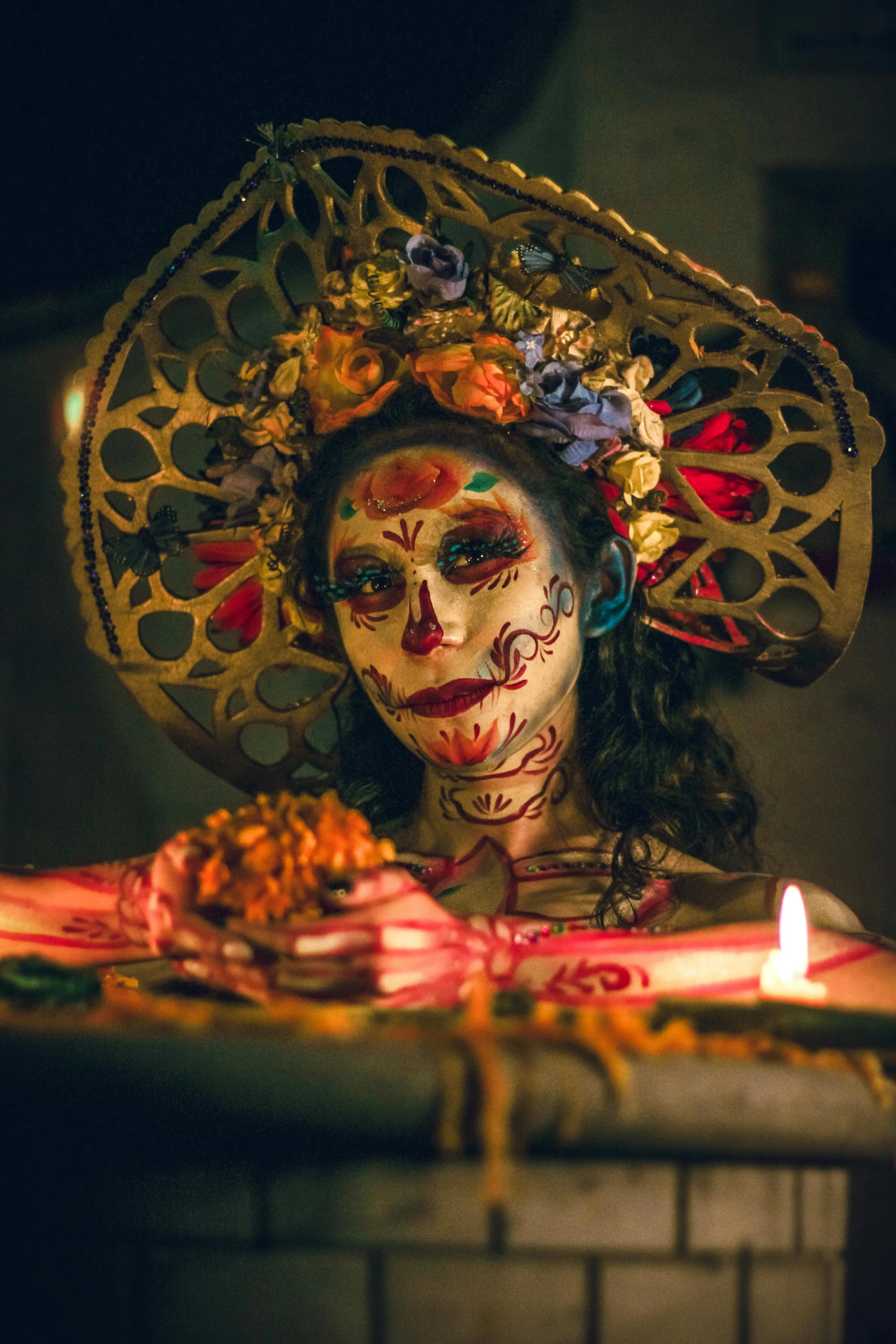 Woman in Day of the Dead Makeup with Candle at Altar