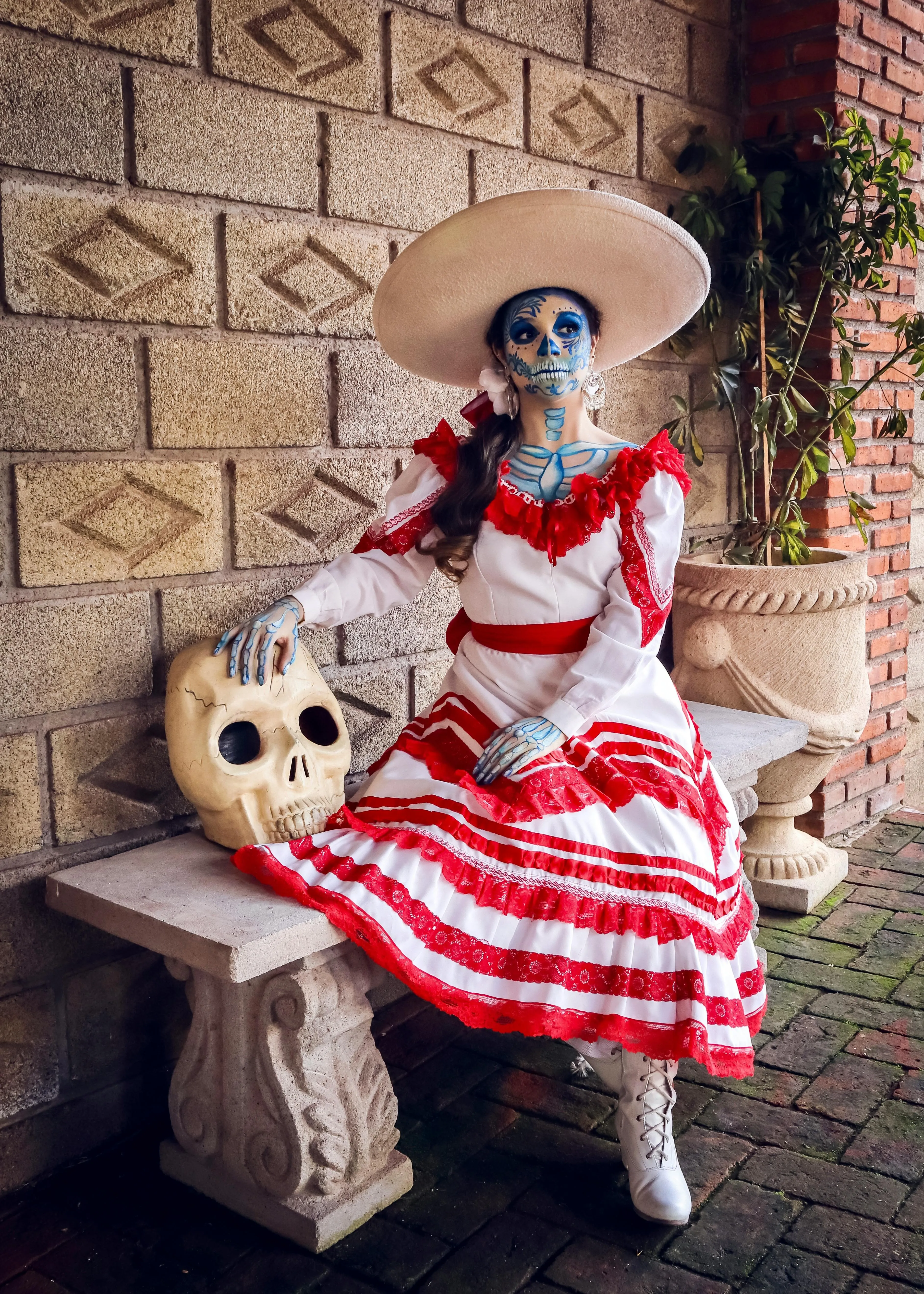 Woman in Red and White Dress with Skull Makeup Sitting