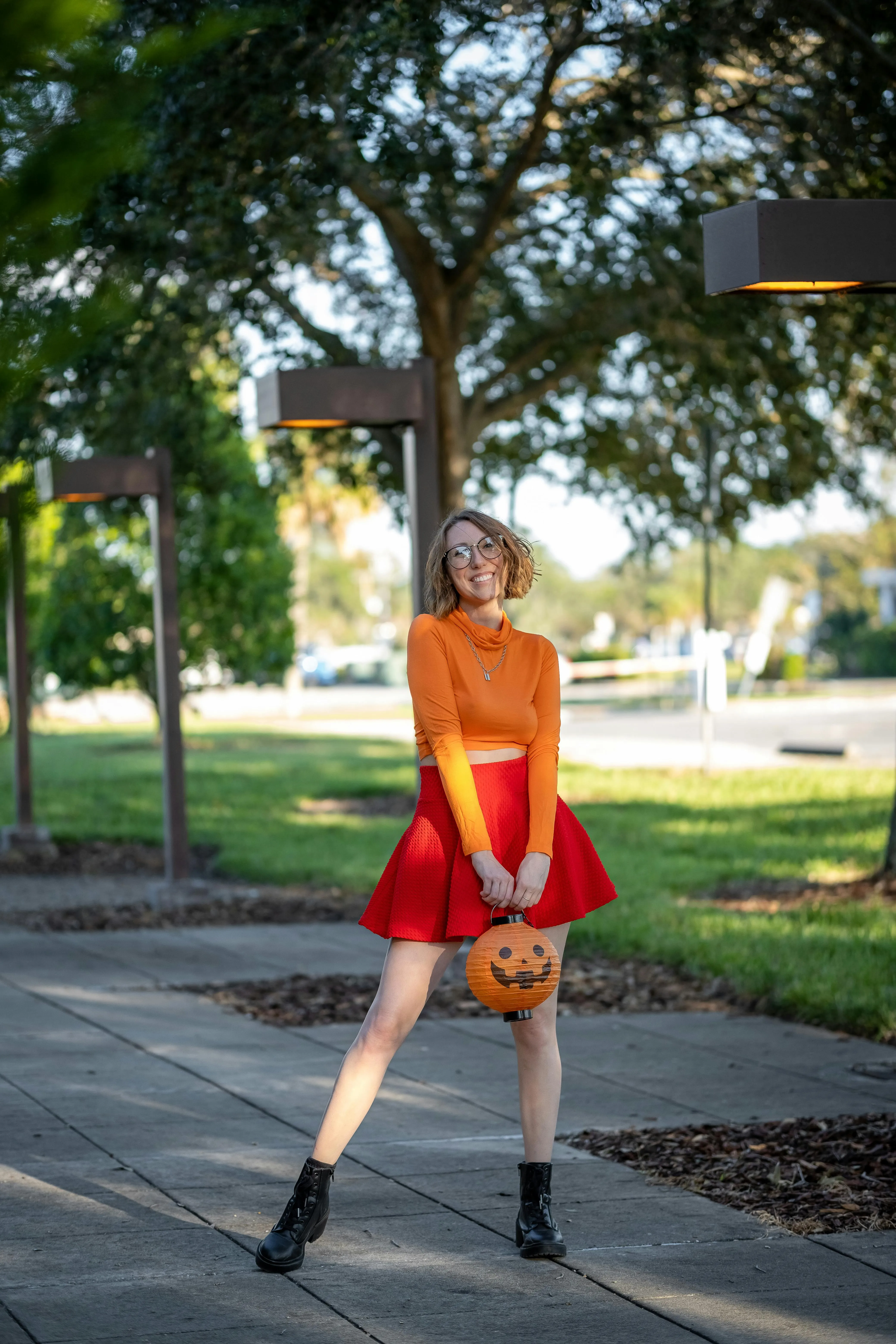 Woman in Red Dress with Pumpkin Head on Sidewalk image