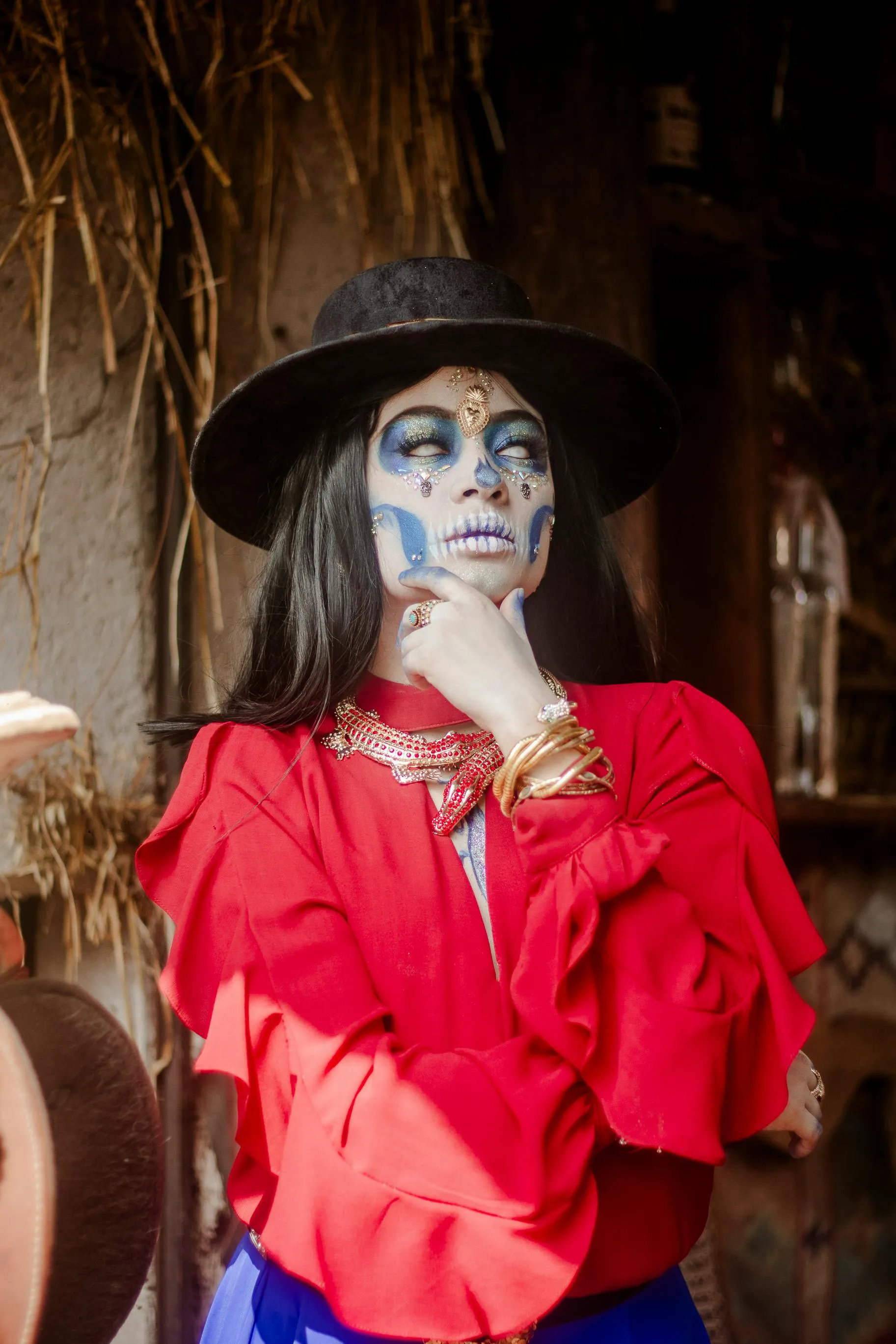 Woman in Red Shirt with Skull Makeup and Wide Brim Hat