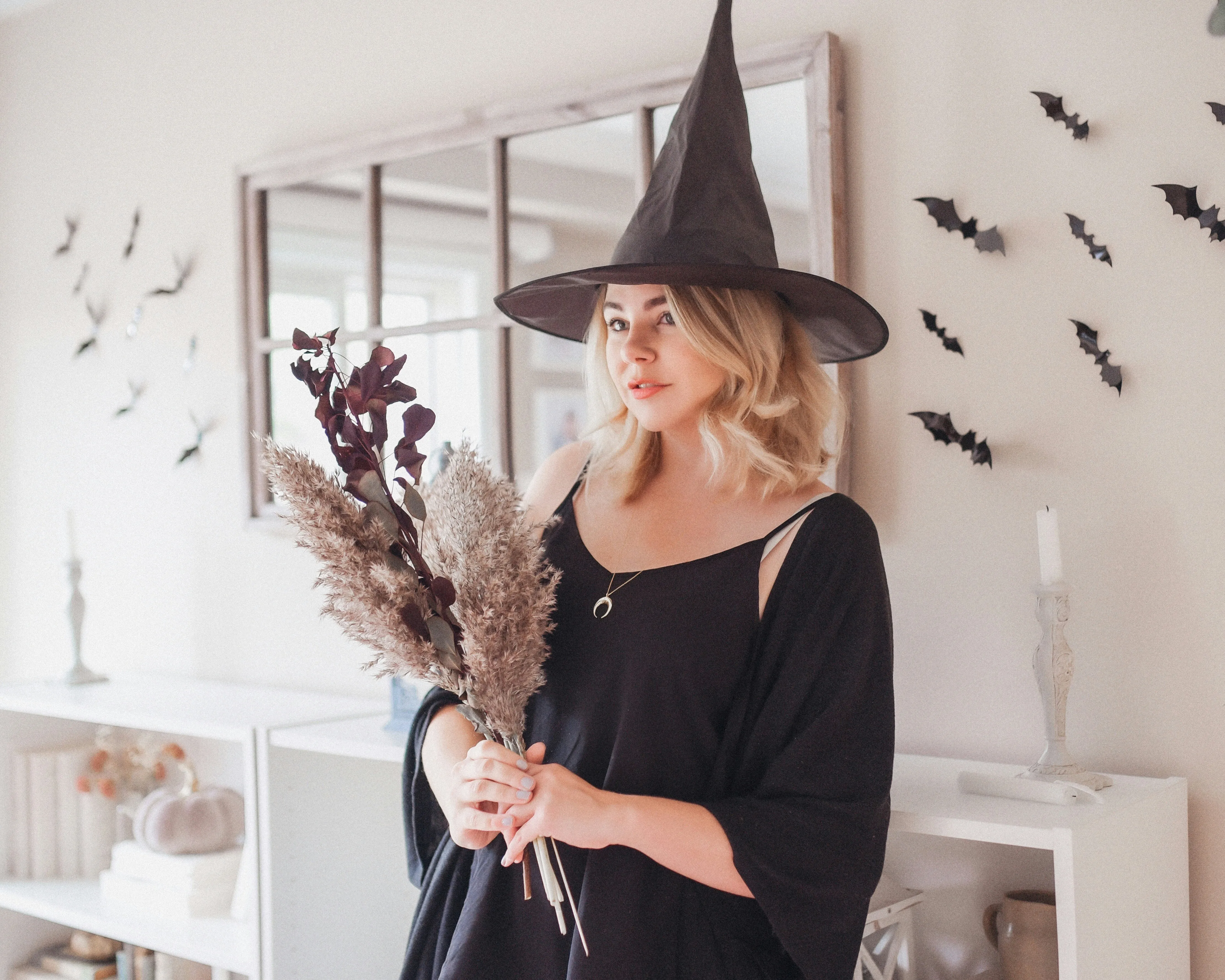 Woman in Witch Costume Holding Halloween Decorations