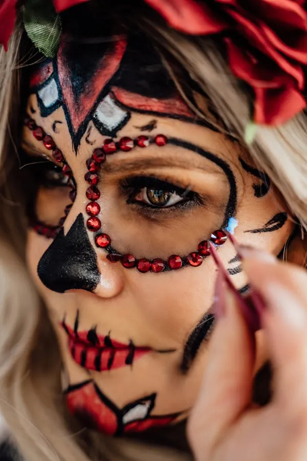 Woman touching face with bold skeleton makeup and design